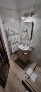 a bathroom with a sink and a mirror at Popasul Moților in Răchiţele