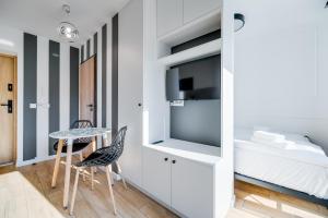 - une chambre avec un lit, une table et des chaises dans l'établissement Carbon by OneApartments, à Sopot