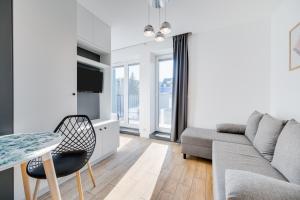 a living room with a couch and a table at Carbon by OneApartments in Sopot