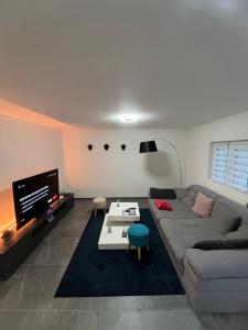 ein Wohnzimmer mit einem Sofa und einem TV in der Unterkunft Entire Private House in Roveredo