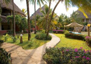 a resort with a garden with palm trees and a walkway at Tembo Court Apartments(2 Bdrm) in Malindi