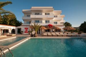 a hotel with a swimming pool in front of a building at Apartamentos Sunset Oasis Ibiza - Only Adults in San Antonio Bay