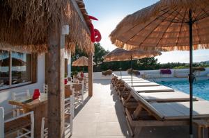 a resort with tables and chairs and a swimming pool at Apartamentos Sunset Oasis Ibiza - Only Adults in San Antonio Bay