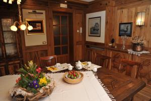 a dining room with a table with flowers on it at Bonavia B&B in Sistiana