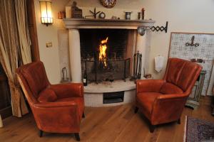 a living room with two chairs and a fireplace at Bonavia B&B in Sistiana