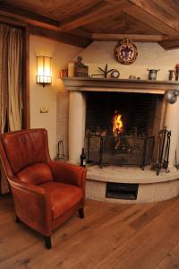 a living room with a fireplace and a chair at Bonavia B&B in Sistiana