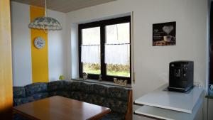 sala de estar con sofá y ventana en Großzügige Wohnung mit Terrasse und Gartenzugang., en Bindlach
