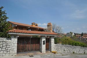 a house with a gate and a stone fence at Bonavia B&B in Sistiana