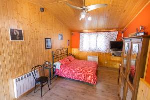 a bedroom with a red bed and a ceiling fan at Camping Anzánigo in Anzánigo