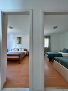 a bedroom with two beds and a mirror at Apartments Cvitanović Korčula in Korčula