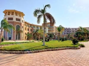 un gran edificio con palmeras delante en Royal Beach Private Apartments Hurghada en Hurghada