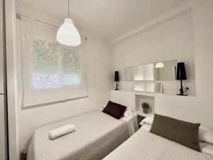 a small room with two beds and a light at Kinahouse in Córdoba