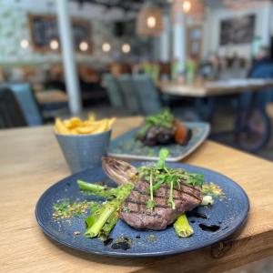 twee borden voedsel op een tafel met vlees en groenten bij Hotel-restaurant "Lely" in Oude-Tonge