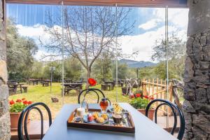 uma bandeja de comida numa mesa em frente a uma janela em Il Rifugio em Baunei