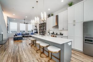 a kitchen with white cabinets and a bar with stools at Close to Uptown / Downtown in Dallas
