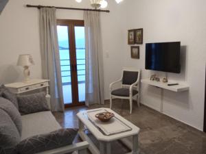 a living room with a couch and a tv at Marilena Panoramic Sea View House in Elounda