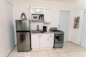 a kitchen with a stainless steel refrigerator and a stove at Green Studio 1 - just 7 min drive to the beach in Rincon +6 photos