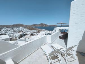 balkon z białymi krzesłami i widokiem na miasto w obiekcie Mia casa w mieście Nausa