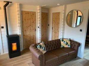 ein Wohnzimmer mit einem Sofa und einem Holzofen in der Unterkunft Gîtes Douillets : Chalet sur Pilotis in Houyet