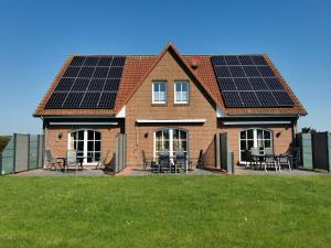 ein Haus mit Sonnenkollektoren auf dem Dach in der Unterkunft Ferienhaus Baltrumkieker Mitte in Neßmersiel
