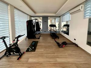 a gym with several treadmills and exercise bikes at The Fjord at Libi Apartment in Accra