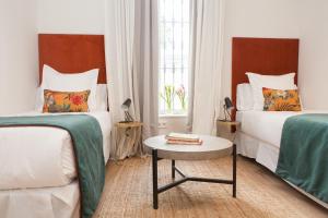 a hotel room with two beds and a table at Indulge in Seville C in Seville