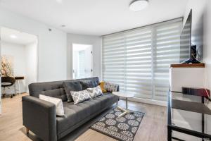 a living room with a gray couch and a table at Modern DT Vancouver 1BD Condo in Vancouver