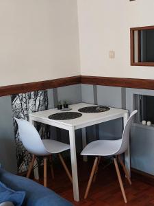 a small white table and two chairs in a room at Apartament Radosna in Gdynia