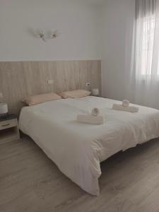 ein großes weißes Bett mit zwei Handtüchern darauf in der Unterkunft Sunset view in La Romantica, 2 in Los Realejos