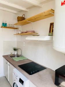 a kitchen with a sink and a stove top oven at Maisonnette climatisée à 35m de la plage de La Capte Hyères in Hyères