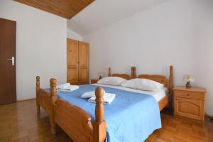 a bedroom with two beds and a blue bedspread at Apartmani Erna in Pašman