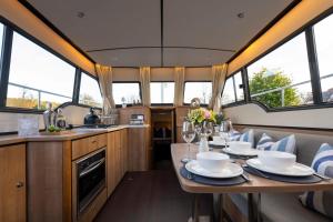 una cocina con mesa de comedor en un barco en Knightsdream - Unforgettable 2 Night Stay en Henley on Thames