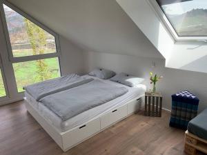 een witte slaapkamer met een bed in een kamer met ramen bij Wohnung am Fuße des Schwarzwalds in Oberkirch