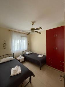 1 dormitorio con 2 camas y ventilador de techo en Seaside House, en Karianí