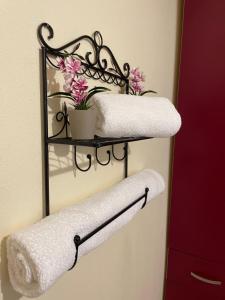 a towel rack with two towels and flowers on it at Seaside House in Karianí +27 photos