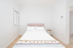 een witte slaapkamer met een bed met een tapijt op de vloer bij Stunning Athens Riviera 3 BD Apt in Athene