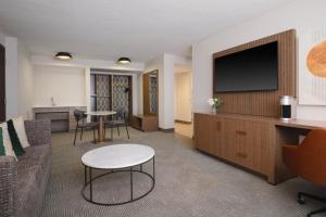 een woonkamer met een bank en een flatscreen-tv bij Holiday Inn Chicago O'Hare - Rosemont, an IHG Hotel in Rosemont