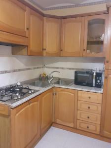 a kitchen with wooden cabinets and a sink and a microwave at La Casa di Romeo in Ateleta