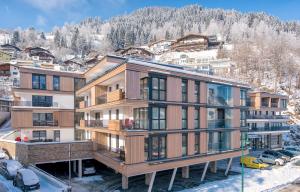 ツェル・アム・ゼーにあるAlpin & Seeresort Top 10 - by Alpen Apartmentsの山の景色を望むアパートメントビル