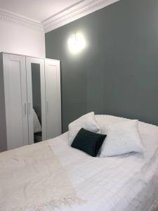 - un lit blanc avec un oreiller noir dans l'établissement SAINT DENIS ELEGEANCE, à Saint-Denis
