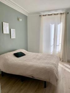 Ce lit se trouve dans un dortoir blanc doté d'une fenêtre. dans l'établissement SAINT DENIS ELEGEANCE, à Saint-Denis
