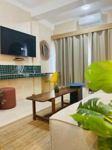 a living room with a table and a tv at Hotel Amaca Puerto Vallarta - Adults Only in Puerto Vallarta