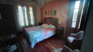 a bedroom with a bed and a chair and windows at Casa Funes in Funes
