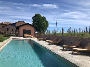 una piscina con tumbonas y una casa en Agriturismo Cascina del Rosone, en Agliano Terme