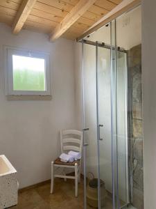 baño con ducha de cristal y silla en B&B Dimora Castello, en Galatone