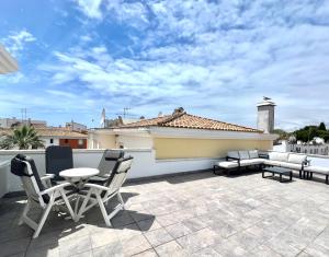 a patio with a table and chairs on a roof at Nancy Apartment - Near Vilamoura Marina by HD PROP in Vilamoura