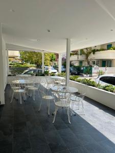 een groep tafels en stoelen op een patio bij Hotel Exclusive in Riccione