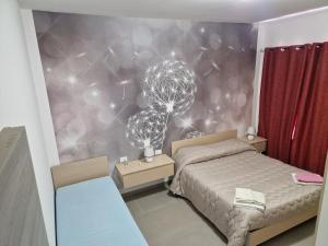 a bedroom with a bed and a dandelion wall at Nina's house 1 a 300 metri dal mare in Santa Caterina Dello Ionio Marina