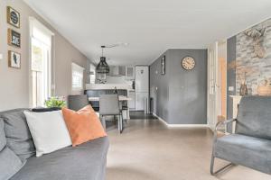 a living room with a couch and a dining room at Ruime Luxe Chalet midden in de Veluwe. in Hoenderloo