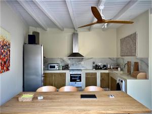 a kitchen with a wooden table and a ceiling fan at Tranquil chic retreat in Heraklio